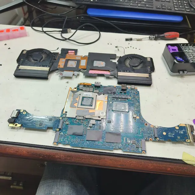 Laptop motherboard and dual fan heatsink disassembled for cleaning