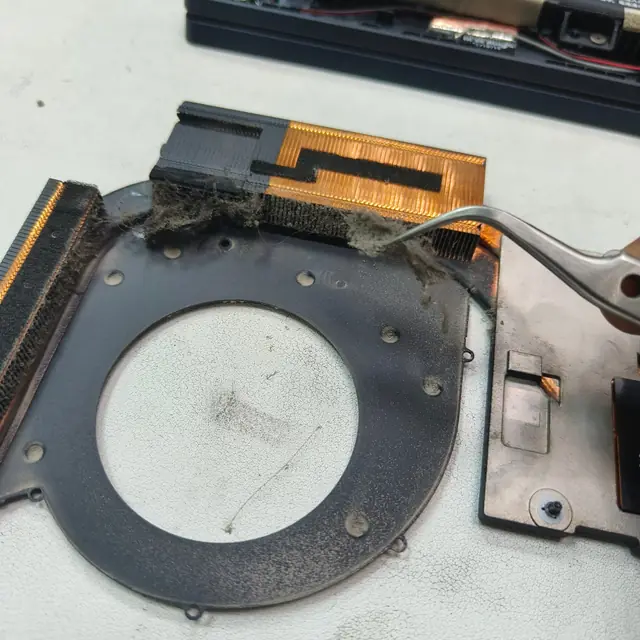 Removing dust from laptop heatsink with tweezers